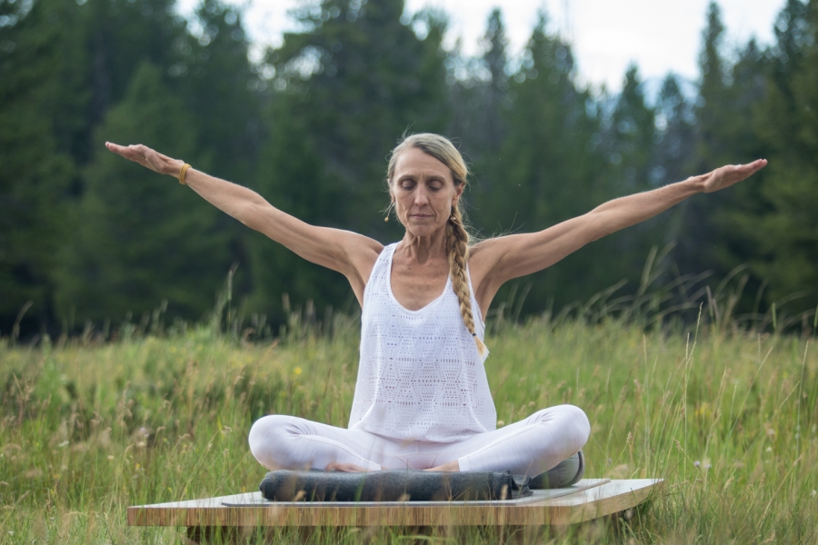 Woman practicing a kundalini yoga kriya extends her arms