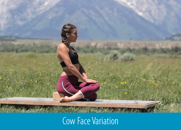 cyclist practices cow face pose during a yoga class outdoors - yogatoday