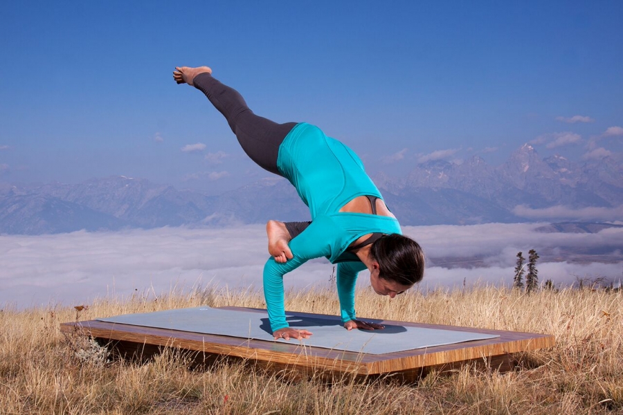 woman practices an advanced arm balance -yogatoday