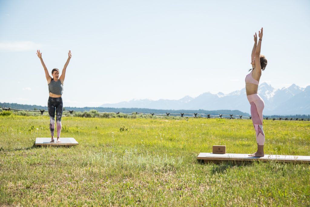yoga teacher and student practice sun salutations -yogatoday
