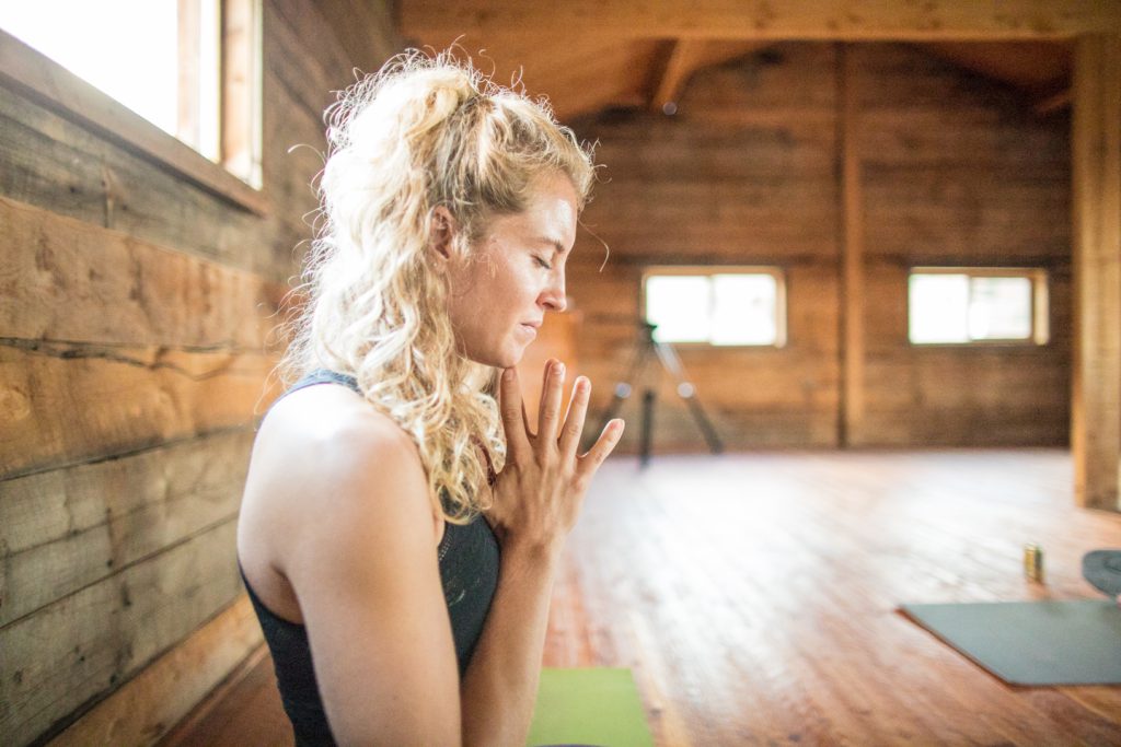 yoga teacher with her hands in prayer pose