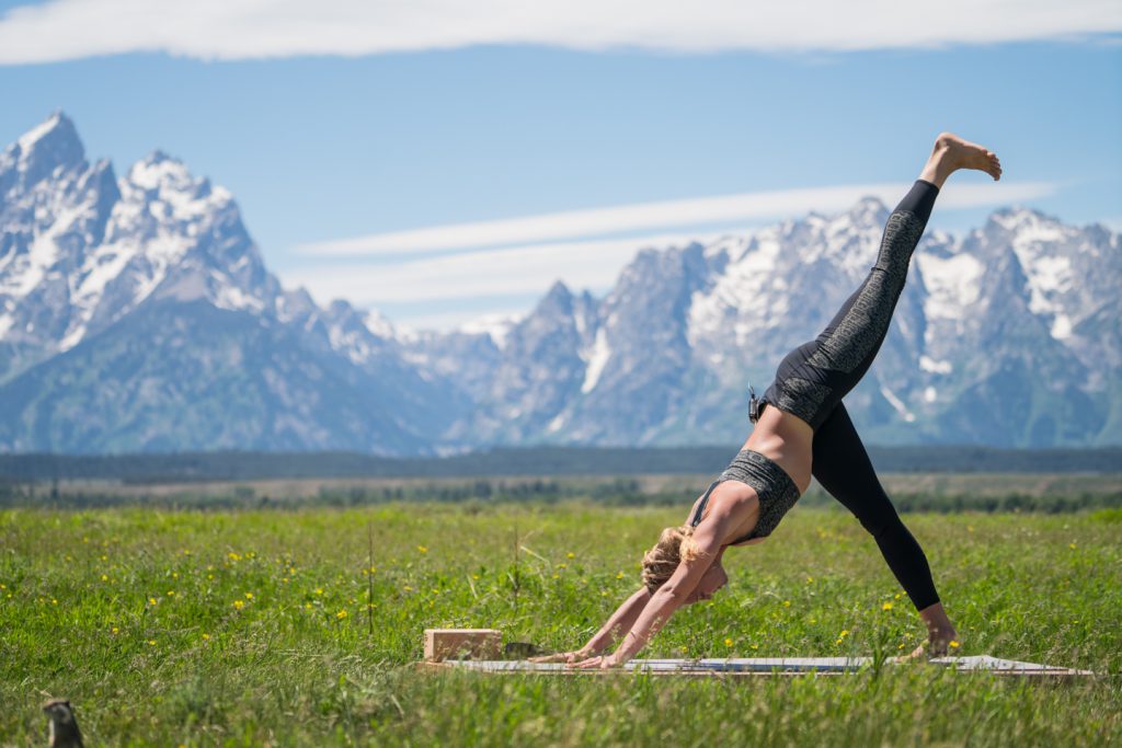 woman practices downward facing dog - yogatoday