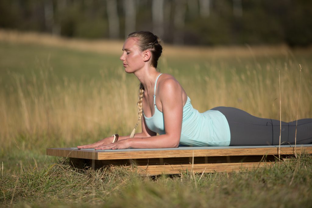 yogi practices sphinx pose outdoors - yogatoday